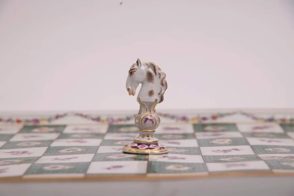 Historic 1748 Meissen porcelain chessboard and knight piece with pink and green floral decorations.